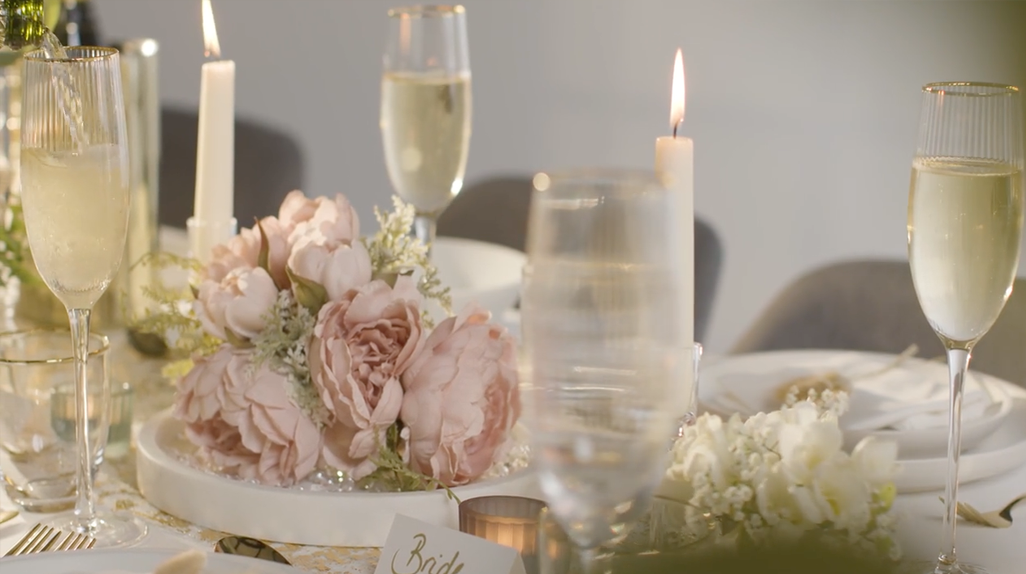 Tavola con bicchieri e centrotavola di rose